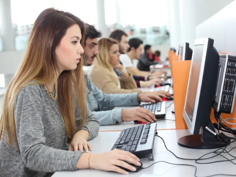 Studenten arbeiten an Laptops während eines IT-Kurses