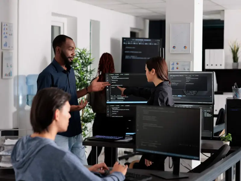 Lernende Person arbeitet mit Code-Editor und Notizen am Schreibtisch